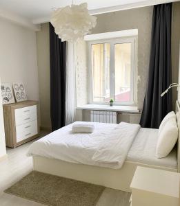 莫斯科的住宿－Aparthotel Lind，卧室配有白色的床和窗户。