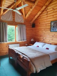 a bedroom with a large bed in a log cabin at Hosteria Epulen in Villa La Angostura