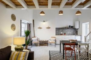 a living room with a table and chairs and a kitchen at Fisherman's Inn Loft in Montijo