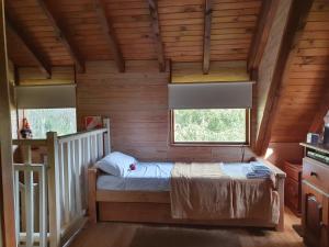um quarto com uma cama num chalé de madeira em Cabaña Modern Family em Villa La Angostura