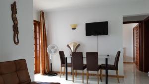 una sala da pranzo con tavolo, sedie e TV di Island Village ad Adeje