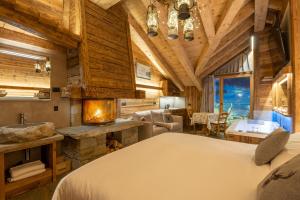 a hotel room with a large bed and a large window at Park Chalet Village in Livigno