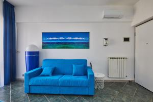 a blue couch in a living room with a painting on the wall at Biancoeblu in Albisola Superiore +35 photos