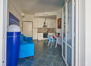 a living room with a blue couch and a kitchen at Biancoeblu in Albisola Superiore