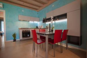 une cuisine avec une table à manger et des chaises rouges dans l'établissement Peschiera Terrace, à Peschiera del Garda