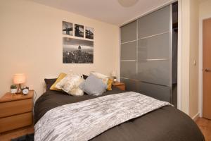 een slaapkamer met een bed en een grote glazen kast bij The Hub - Spacious, bright and modern with free parking in Milton Keynes
