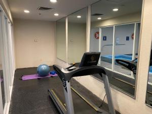 een kamer met een fitnessruimte met een loopband en een spiegel bij Quality Inn Monterrey La Fe in Monterrey