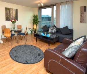 ein Wohnzimmer mit Sofa und Tisch in der Unterkunft The Hub - Spacious, bright and modern with free parking in Milton Keynes + 12 Fotos