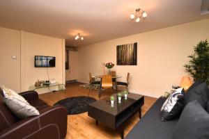 een woonkamer met een bank en een tafel bij The Hub - Spacious, bright and modern with free parking in Milton Keynes