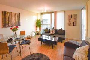 ein Wohnzimmer mit Sofa und Tisch in der Unterkunft The Hub - Spacious, bright and modern with free parking in Milton Keynes