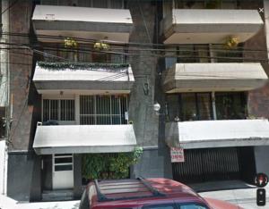 er staat een rode auto voor een gebouw geparkeerd bij Vive la Roma, ubicación ideal in Mexico-Stad