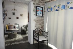 Habitación con puerta con silla y sofá en Maison du chat bleu en Saint-Hilaire-de-Clisson