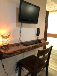 a wooden desk with a television and a lamp at Pilgrim Inn in Caronport