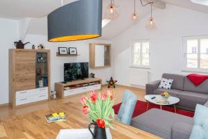 a living room with a couch and a tv at Rooftop - das Apartment mit Dachterrasse in Dresden