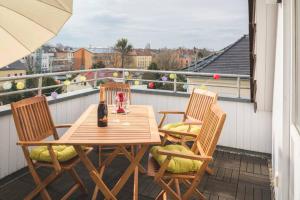 a wooden table and two chairs on a balcony at Rooftop - das Apartment mit Dachterrasse in Dresden