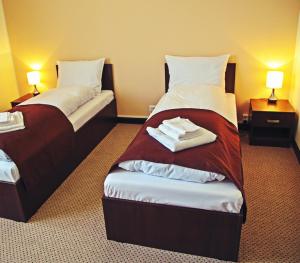 2 camas en una habitación de hotel con toallas en la cama en Cazare Karmina en Baia Mare