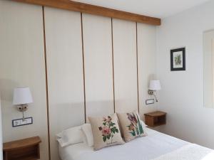 a bedroom with white walls and a bed with pillows at Hostal El Panadero in Sepúlveda