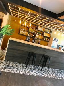 a bar with two stools sitting at a counter at HOTEL CASA MAYOR LA 70 in Medellín