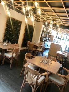a restaurant with wooden tables and chairs with lights at HOTEL CASA MAYOR LA 70 in Medellín