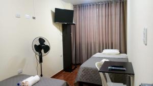 Habitación de hotel con 2 camas y escritorio en Hospedaje turístico Peruvian Wasi en Lima