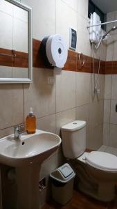 uma casa de banho com um lavatório, um WC e um espelho. em Hospedaje turístico Peruvian Wasi em Lima