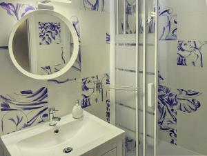 bagno con lavandino e doccia con piastrelle blu e bianche di Guesthouse Tricana de Aveiro ad Aveiro Altre 65 foto