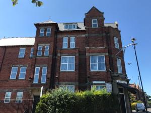 an old red brick building with a clock tower at Newcastle West Hotel & Bar in Elswick