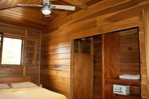 a bedroom with wooden walls and a ceiling fan at M&M's Residencias in Bocas Town