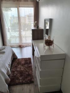 a bedroom with a bed and a dresser with a mirror at Tália Mar in Vilamoura