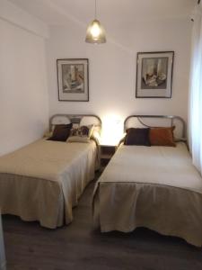 2 camas en una habitación con ventana en Bnap Gesta, en Oviedo