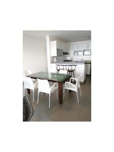 a kitchen and dining room with a table and chairs at Paracas Apartment in Paracas