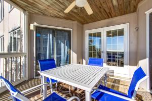 a white table and blue chairs on a porch at Tidewater H-203 in Isle of Palms