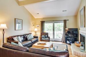 a living room with a leather couch and a table at Fairway Dunes 3 in Isle of Palms