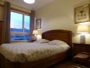 a bedroom with a bed with two lamps and a window at A View to the River Tejo by SixtyFive Boutique Home in Lisbon