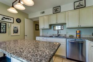 cocina con armarios blancos y encimera de granito en Beach Club 341, en Seabrook Island