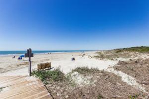 a beach with a bench and people on the sand at Shipwatch 2373 in Kiawah Island