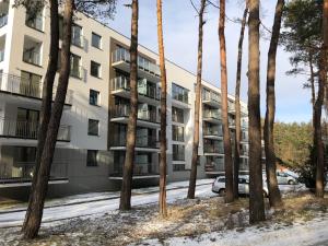 un condominio con alberi in primo piano di Family & Business Sauna Apartments No 7 Leśny nad Zalewem Cedzyna Unikat - 3 Bedroom with Private Sauna, Bath with Hydromassage, Terrace, Garage, Catering Options a Kielce