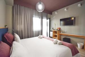 Un dormitorio con una gran cama blanca y una ventana en Be My Guest Athens en Athens