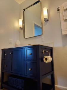 a bathroom with a blue cabinet and a mirror at Point Arena Lighthouse in Point Arena