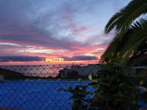 カンデラリアにあるCandelaria's Mountain House (Pool & Sea Views)の夕日を背景に囲まれた柵