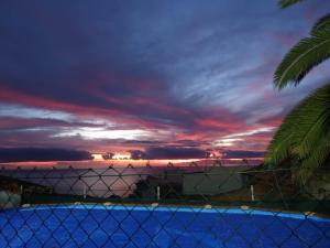 カンデラリアにあるCandelaria's Mountain House (Pool & Sea Views)の塀越しの夕日