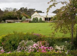 una casa con un gran patio con flores en Tairoa Lodge en Hawera