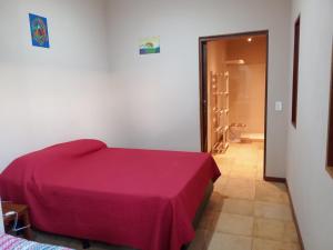 1 dormitorio con cama morada y baño en LA MAISON OLIVER SPEEDS, en São Miguel do Gostoso