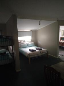a bedroom with a bed and two bunk beds at Ithaca 1896 Manor in Busselton