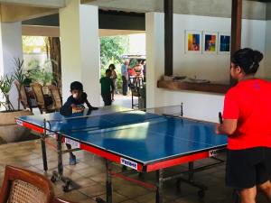 a group of people standing around a ping pong table at Hotel Sunflower in Kataragama