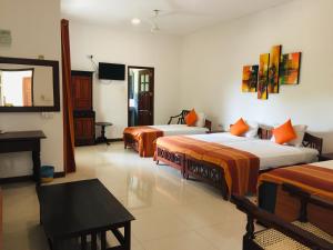 a hotel room with two beds and a mirror at Hotel Sunflower in Kataragama