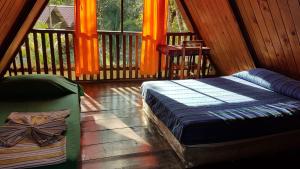 a bed room with two beds and a window at El Portal De Champey in Lanquín