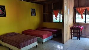 a bedroom with two beds and a window at El Portal De Champey in Lanquín