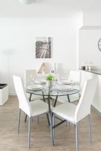 a dining room with a glass table and white chairs at Brisbane City Apartments (Tank St CBD) in Brisbane