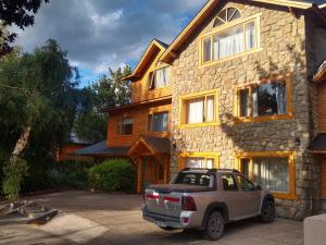 un camión estacionado frente a una casa de piedra en Las Golondrinas en San Martín de los Andes